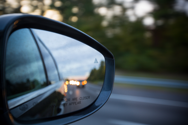 side-view mirror of car with traffic in the reflection