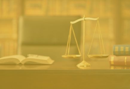 scales of justice on lawyer's desk with legal books