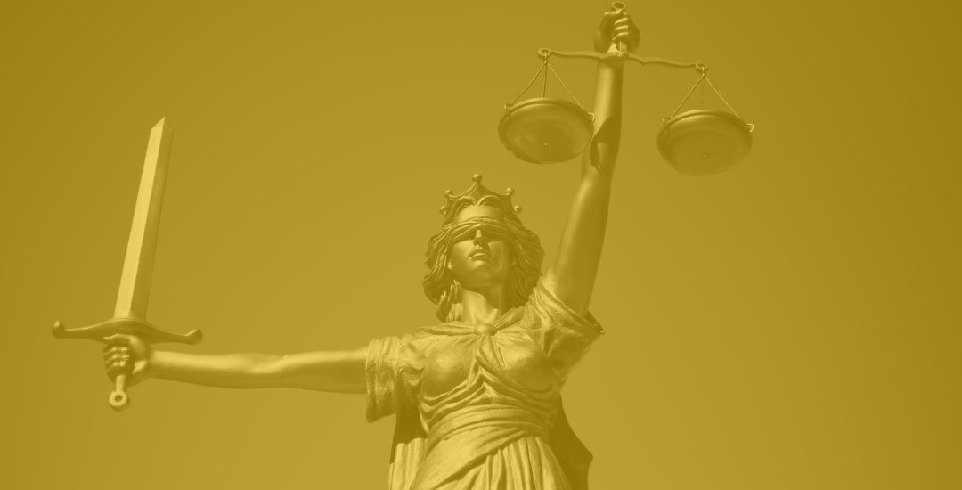 image looking up at lady liberty statue with sword and scales