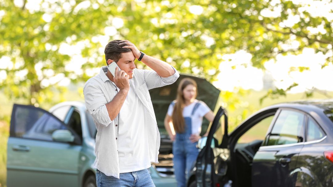 2 people assessing the damage of their cars after a crash