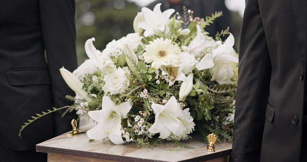 Image of white floral bouquet on top of coffin