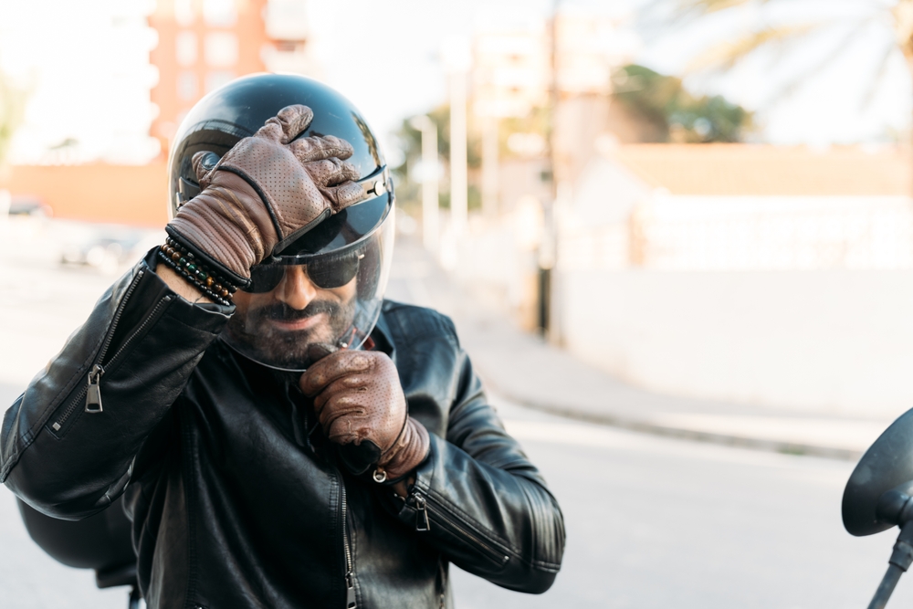 Motorcycle rider adjusting helmet