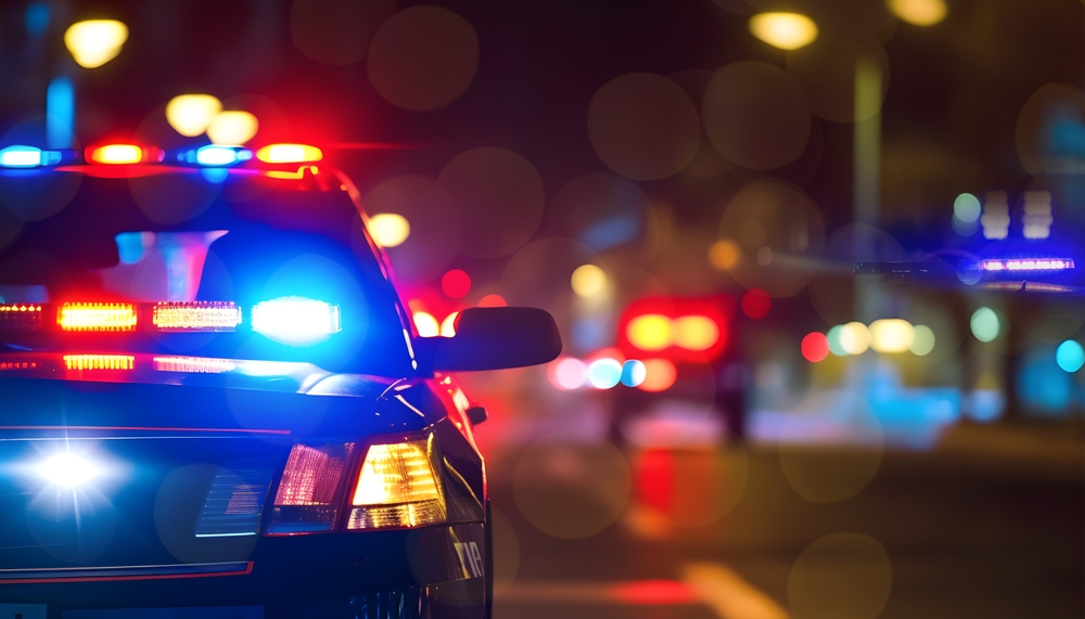 Image of police cars at night with emergency lights on