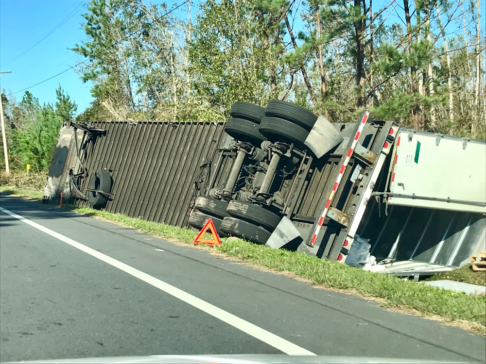 Semi-truck tipped over on the side of the interstate