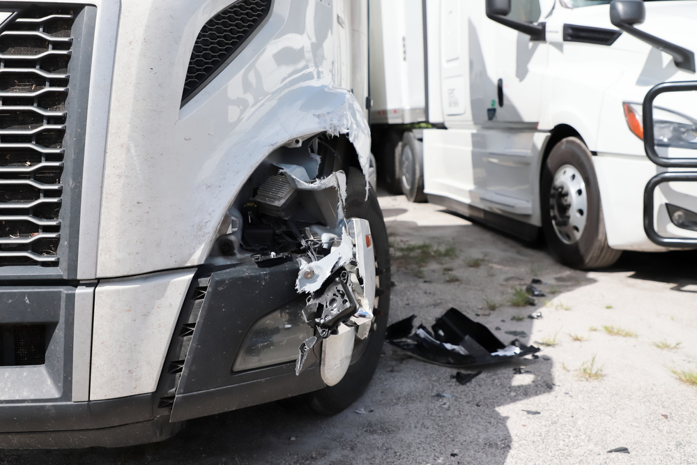 Close-up view of semi truck with damage to front wheel