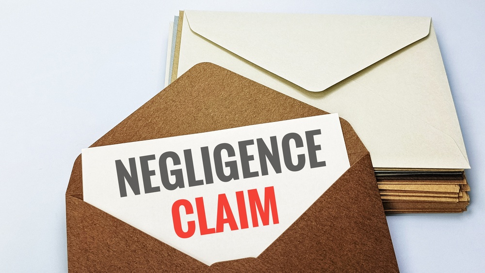 Negligence Claim concept on envelope representing civil liability breach of duty damages compensation lawsuit legal case. 